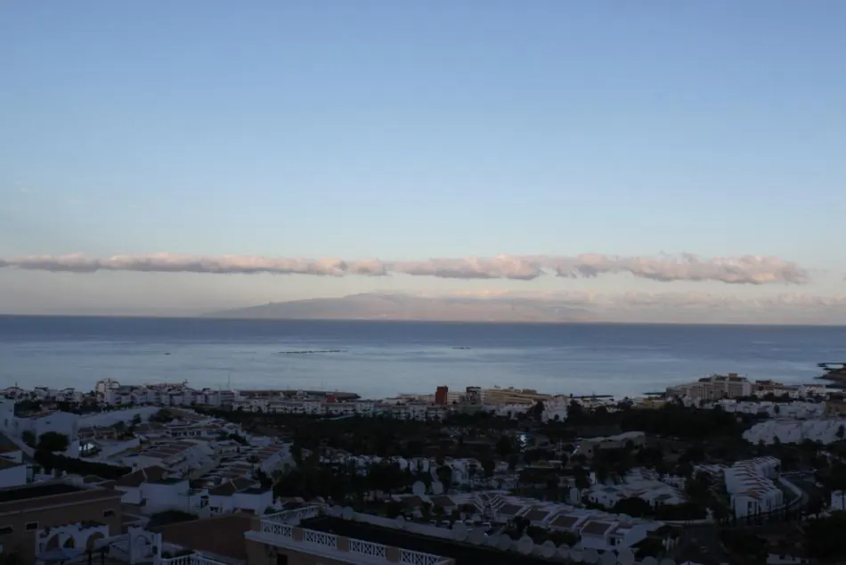 Evening view over the rooftops of a south Tenerife town to the sea