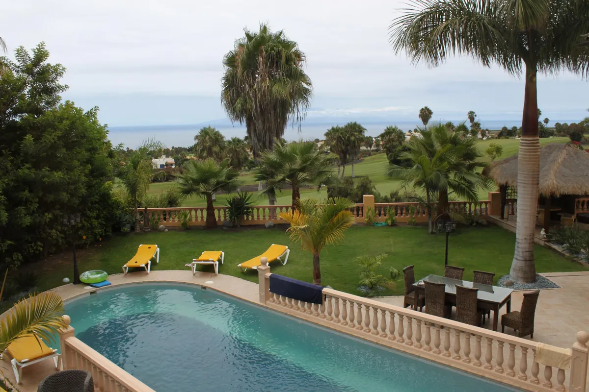 Villa garden with a swimming pool, palm trees and sea view in Tenerife